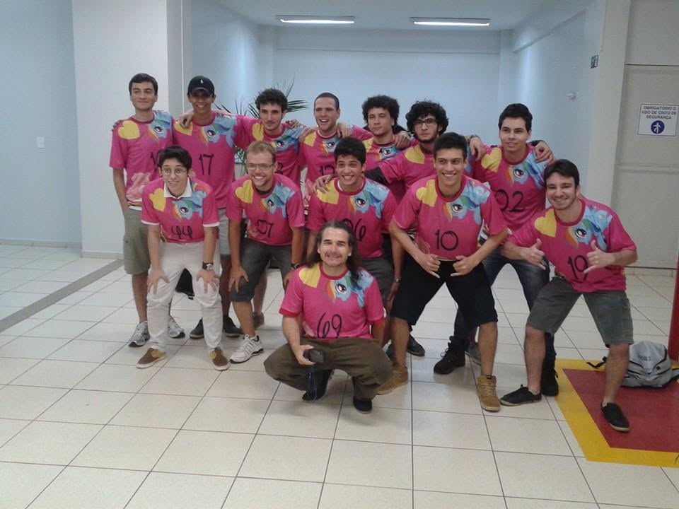 A college football team in matching pink t-shirts with a colourful eye design
